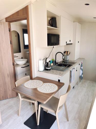 une petite cuisine avec une table et des chaises en bois dans l'établissement Petit cocon Douillet, à Fos-sur-Mer