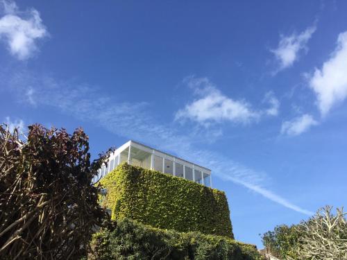 a building with a green wall and a blue sky at Casa Senhora da Rosa in Ponta Delgada