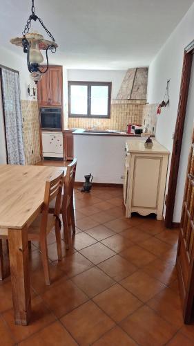 une cuisine avec une table en bois et une table et des chaises dans l'établissement Villa de campagne en Corse, à Lumio