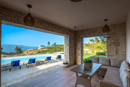 a living room with a couch and chairs and a pool at Villa Natura in Kalamos