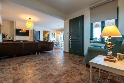 a living room with a couch and a table with a lamp at Villa Natura in Kalamos