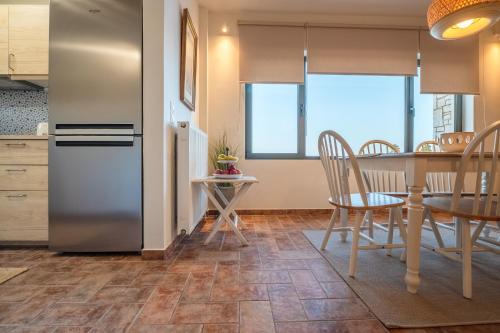 a kitchen and dining room with a table and a refrigerator at Villa Natura in Kalamos