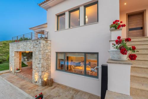 a white house with a fireplace and a patio at Villa Natura in Kalamos