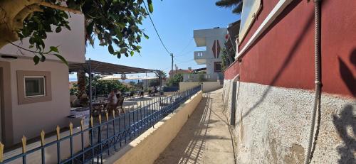 a fence next to a building with people sitting at a table at GLIPTIS Apartments in Karfas