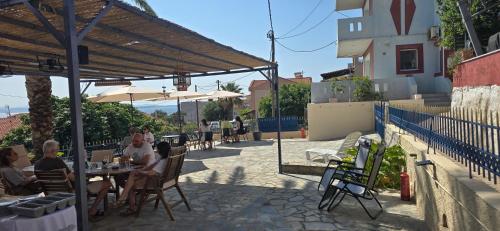 a group of people sitting at a table under an umbrella at GLIPTIS Apartments in Karfas
