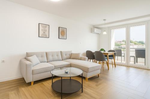 a white living room with a couch and a table at South Panoramic Apartment in the art district of Kapana in Plovdiv