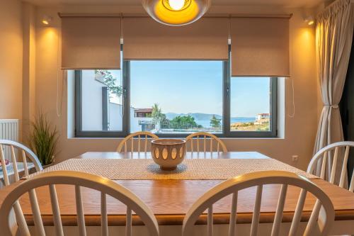 a dining room with a table and chairs and a window at Villa Natura in Kalamos