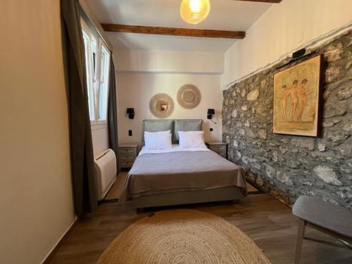 a bedroom with a bed and a stone wall at Magda’s little house in Petra