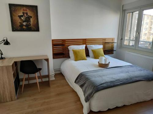 une chambre avec un lit, un bureau et une fenêtre dans l'établissement Grand appartement L'Hélice - Vue port- 4 Chambres, à Boulogne-sur-Mer