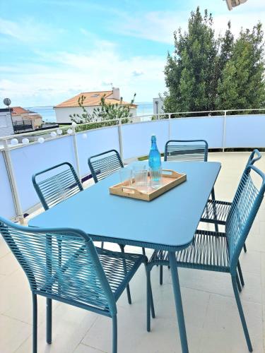 une table bleue et des chaises sur un balcon dans l'établissement Les Portes de l'Océan, à Vaux-sur-Mer