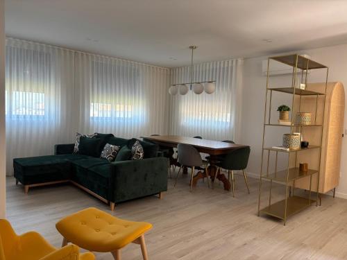 a living room with a green couch and a table at Casa das Eiras, em Cinfães, no Douro in Cinfães