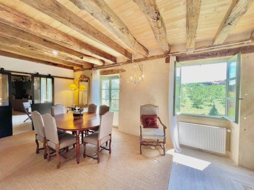une salle à manger avec une table et des chaises en bois dans l'établissement Maison de famille aux portes de Sarlat, à Proissans