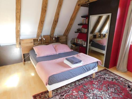 - une chambre dotée d'un lit avec des draps roses et un miroir dans l'établissement Maison de famille aux portes de Sarlat, à Proissans
