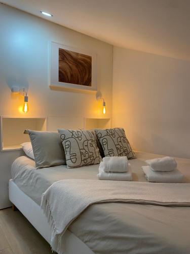 a bedroom with a large white bed with two pillows at Wood Essence Apartment - Cozy Balcony in Coimbra