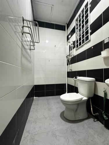 a bathroom with a toilet and black and white stripes at Homestay Ummi Gong Badak 2 in Kuala Terengganu