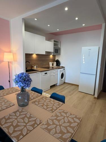 une cuisine avec une table avec un vase de fleurs dessus dans l'établissement Magnifique face à la mer, à Ajaccio