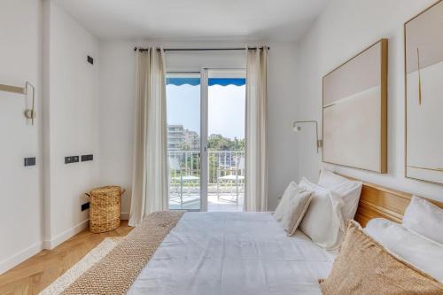 une chambre avec un grand lit avec une grande fenêtre dans l'établissement Dune Croisette - Sea view, à Cannes