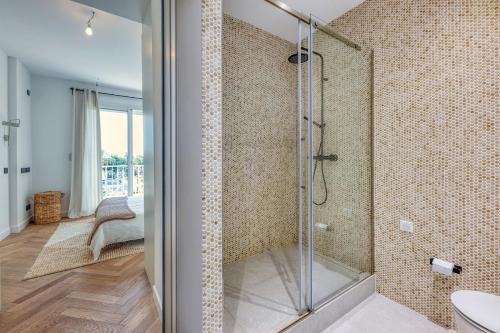 une salle de bain avec une douche avec une porte vitrée dans l'établissement Dune Croisette - Sea view, à Cannes