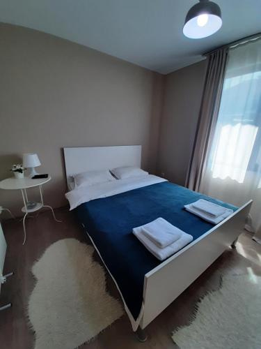 a bedroom with a large bed with a blue blanket at Villa Gardenia in Sapareva Banya