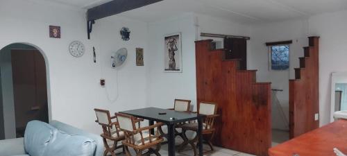 a living room with a table and chairs in a room at Green Escape Cottage Guesthouse in Albert Falls