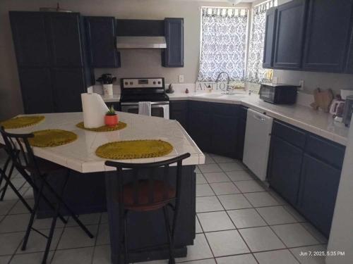 a kitchen with blue cabinets and a table with chairs at Pure Country, plenty of space & trees, relaxing! in Lumberton