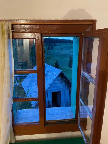 a model of an old barn seen through a window at Domacinstvo Obradovic Nadgora 