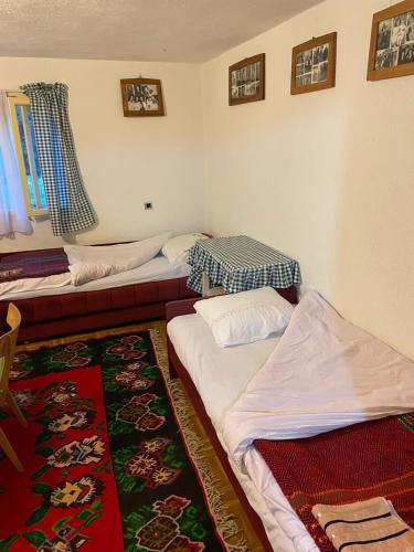 a room with two beds and a rug at Domacinstvo Obradovic Nadgora 