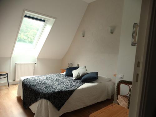 une chambre avec un lit avec des oreillers bleus dessus dans l'établissement Gîtes de la Ferme Auberge de Mésauboin, à Billé