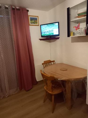 une salle à manger avec une table et une télévision dans l'établissement studio gresse en vercors, à Gresse-en-Vercors