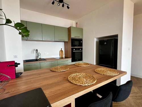 d'une cuisine avec une table en bois et 4 assiettes. dans l'établissement Casamea - Plage 5min, Vue mer, Terrasse, Clim, à Ajaccio