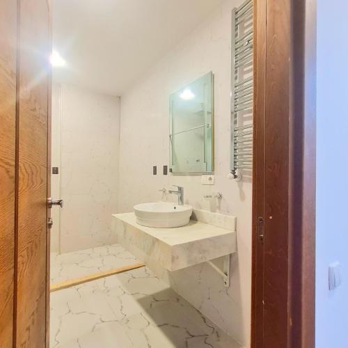 a white bathroom with a sink and a mirror at Panoramic #1 Sea Mountain View 1BR apartment Living Room, Balcony, Kitchen in Batumi
