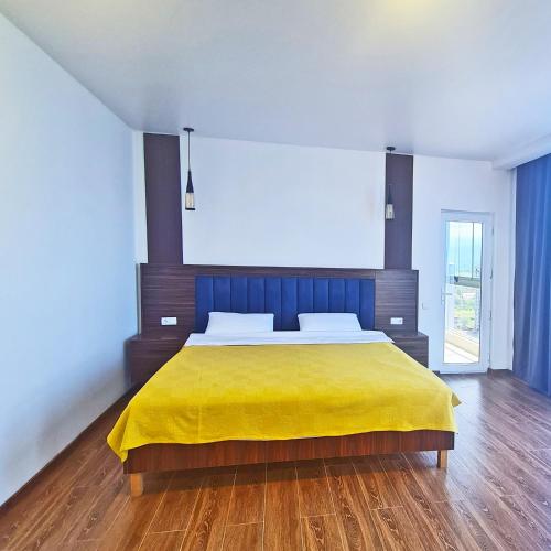 a bedroom with a large bed with a yellow blanket at Panoramic #1 Sea Mountain View 1BR apartment Living Room, Balcony, Kitchen in Batumi