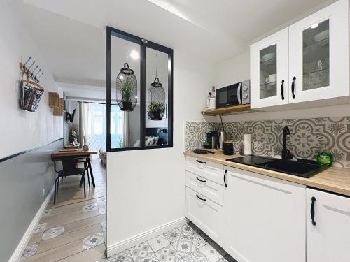 une cuisine avec des armoires blanches et un comptoir dans l'établissement Lou Pitchoun, à Aix-en-Provence