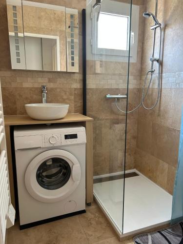 une salle de bain avec une machine à laver et un lavabo dans l'établissement Escale Port Fréjus vue Esterel, à Fréjus