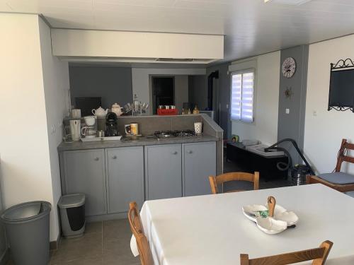une cuisine avec une table blanche et une table et des chaises dans l'établissement La longère de Paul et Suzanne, à Pendé