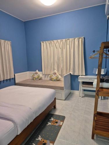 a blue room with two beds and a desk at Ballachulish Rayong 2 BR in Mae Pim
