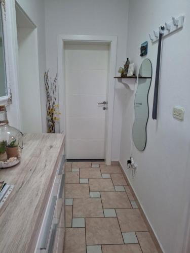 a bathroom with a door and a tile floor at Apartmani Mirela in Krk