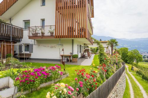 a garden in front of a house with flowers at Haus Karin living in Brixen