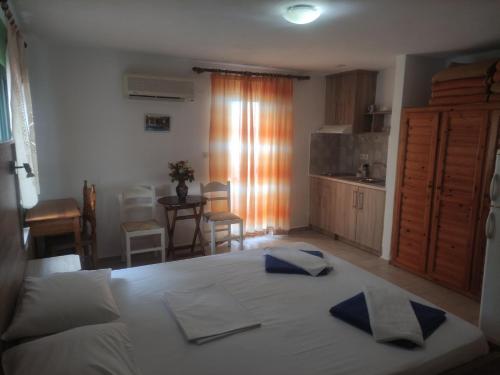 a bedroom with a large white bed and a kitchen at Albatross in Marathokampos