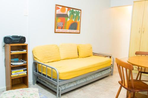 uma cama com um cobertor amarelo em cima em apartamento Edificio Master no Rio de Janeiro