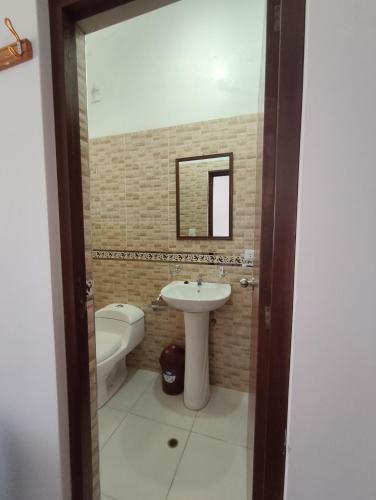 a bathroom with a sink and a toilet and a mirror at Lodge Wayra Wasi in Coporaque