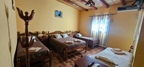 a room with two beds and a couch in it at Cabaña KUYAY in Purmamarca