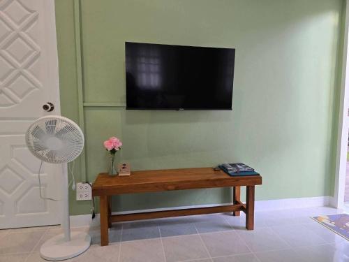 a living room with a table and a flat screen tv at Ballachulish Rayong 2 BR in Mae Pim