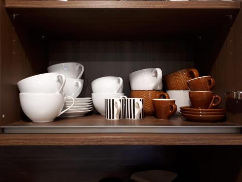 a shelf with cups and other dishes on it at Schafberg Luxury Apartment in St. Wolfgang