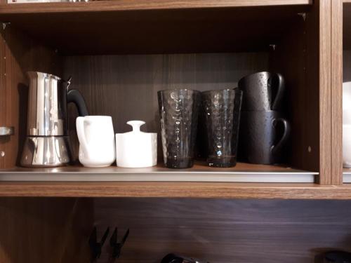 a shelf with several black and white cups on it at Schafberg Luxury Apartment in St. Wolfgang