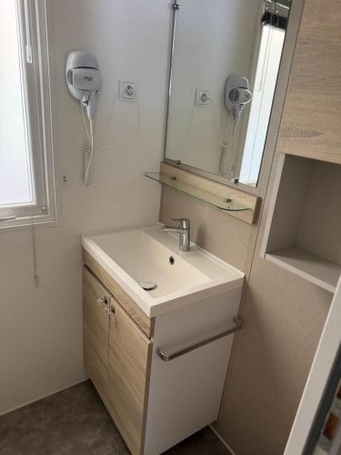 une salle de bain avec un lavabo et un miroir dans l'établissement Mobilhome 3 chambres 2 salles de bains, au Muy