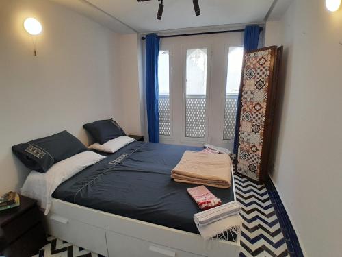 a small bedroom with a bed with a window at Sky Blue in Tangier