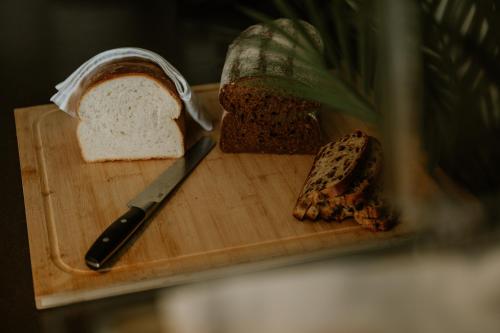 a cutting board with a loaf of bread and a knife at Hotel Jachtlust in Borne