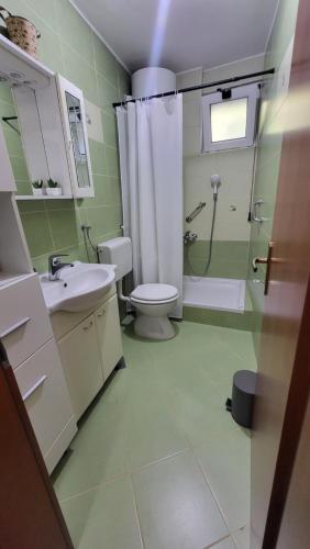 a bathroom with a toilet and a shower and a sink at Apartman Sirius in Skradin