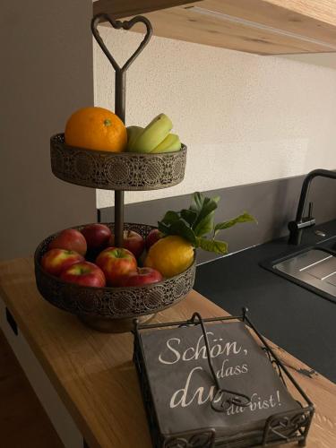 two tiers of fruit on a counter with a sign at Apart Christine in Brixlegg